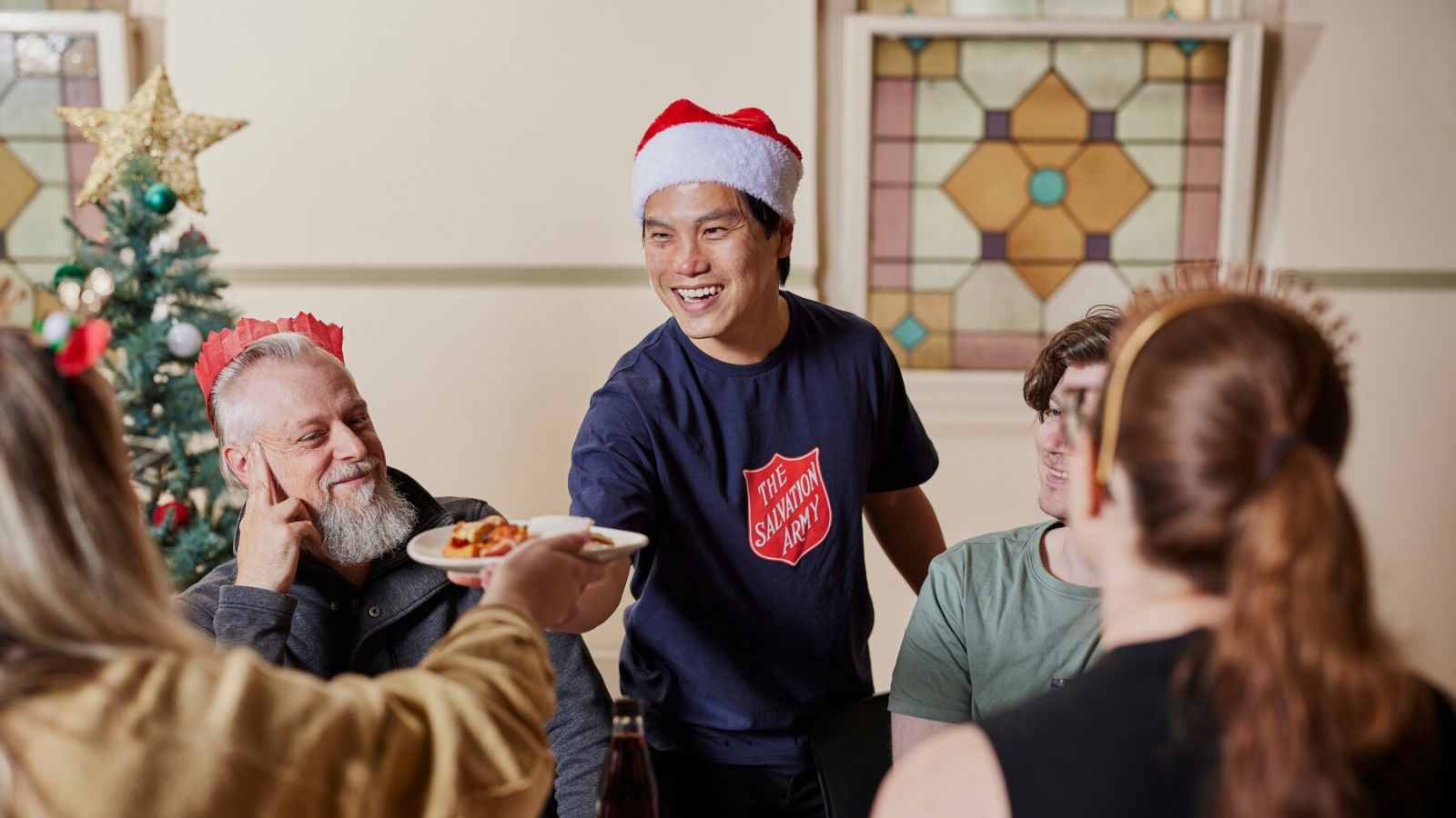 People laughing and sharing a Christmas meal 