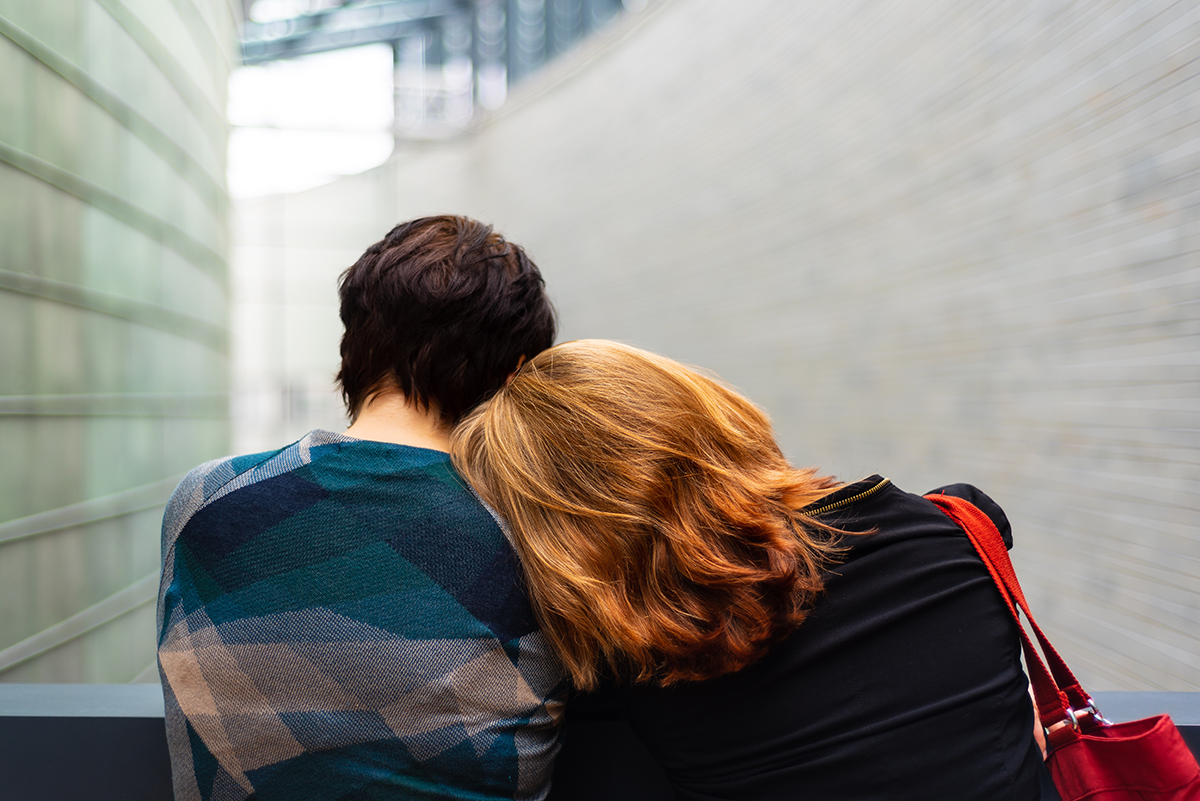 Women laying her head on someone's shoulder